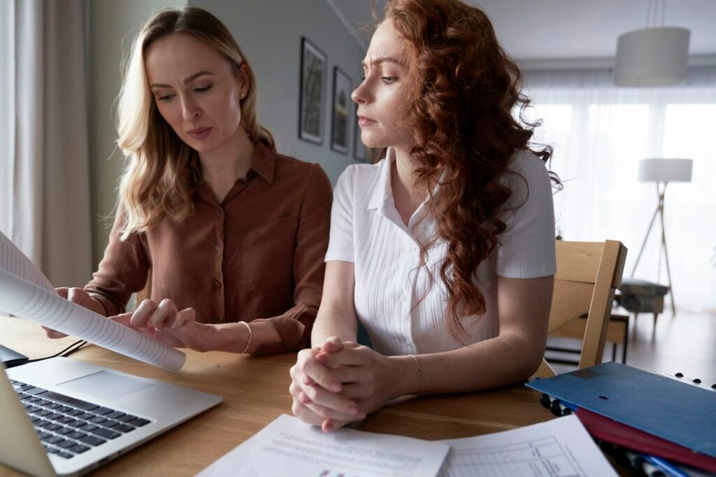Two woman analyzing document at home office